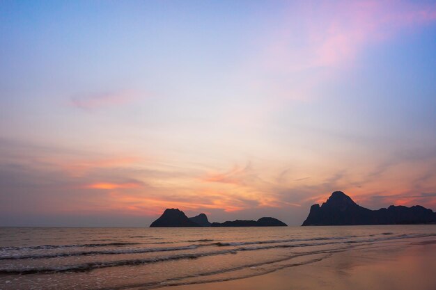 Geweldige strandzonsondergang met eindeloze horizon en eenzame figuren in de verte