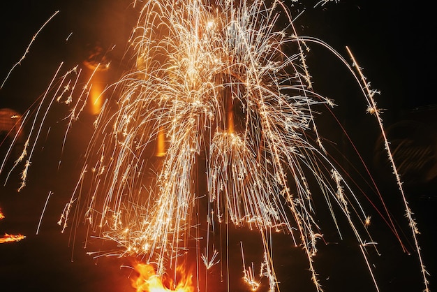 Geweldige vuurshow 's nachts op festival of huwelijksfeest Vuurdansers zwaaien ronddraaiend vuur en man jongleren met heldere vonken in de nachtelijke vuurshowprestaties en entertainment