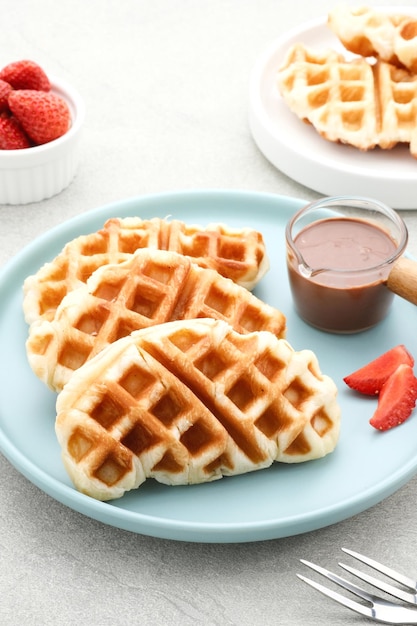 Gewone Croissant Waffle of Croffle met chocoladesaus geserveerd in plaat op grijze achtergrond