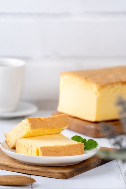 Gewone klassieke Taiwanese traditionele biscuit (Taiwanese castella kasutera) op een houten dienblad achtergrond tafel met ingrediënten, close-up.