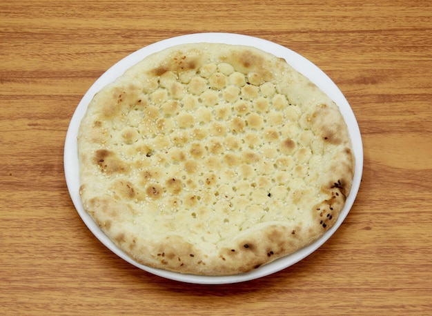 Gewone naan of sada nan nun roti tandoori chapati pitabroodje geserveerd in een schotel geïsoleerd op houten tafel zijaanzicht van Indiaas Pakistaans eten