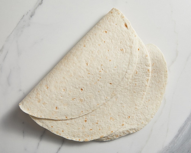 Gewone tortilla wrap op witte achtergrond van bovenaf