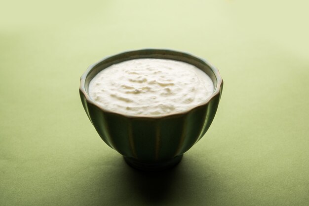 Gewone wrongel of yoghurt of Dahi in het Hindi, geserveerd in een kom op een humeurige achtergrond. Selectieve focus