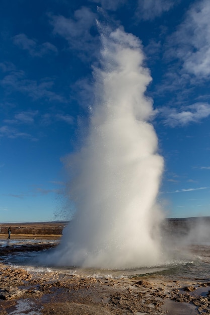 写真 青い空に照らされたアイスランドのゲイザー