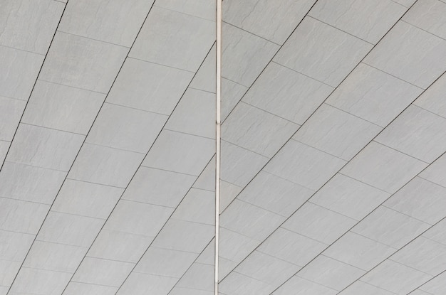 Gezamenlijke lijn tussen twee zijden van gladde ongelijke grijze tegels op muur of vloer, grondoppervlak.
