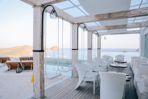 Gezellig café met tafel en stoelen op het dak met uitzicht op zee