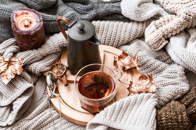 Gezellig de herfstochtend ontbijt op bedstillevenscène. Stomende kop hete koffie, thee die zich dichtbij venster bevindt. Vallen.