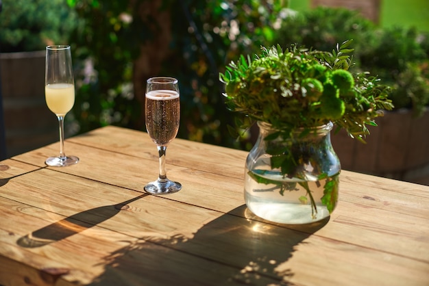 Gezellig terras, glas met champagne op een houten tafel