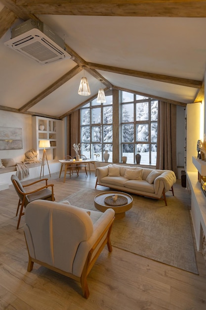 Gezellig warm interieur van een chique landchalet met een enorm panoramisch raam met uitzicht op het winterbos open houtdecoratie warme kleuren en een familiehaard