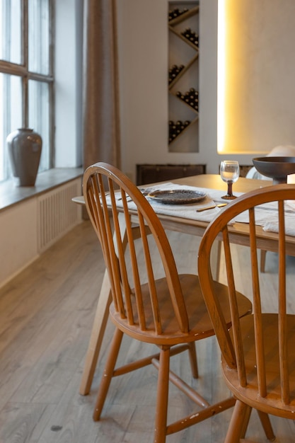 Gezellig warm interieur van een chique landhuis met een open houtafwerking, warme kleuren en een familiehaard uitzicht op de eettafel en tafelsetting