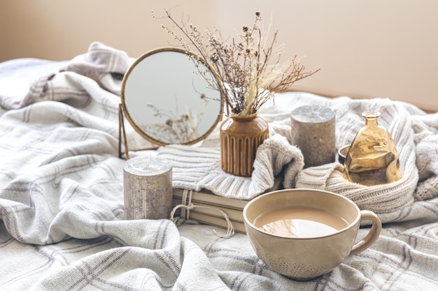 Gezellige herfstcompositie met een kopje koffie en kaarsen in bed