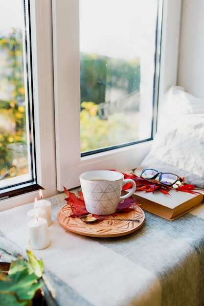 Gezellige herfstochtend met kopje koffie met slagroom en herfstbladeren