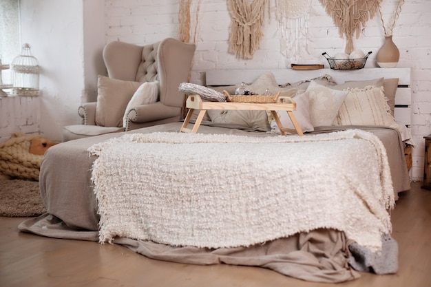 Gezellige kerst ingerichte slaapkamer interieur met fauteuil en bed met kleine tafel op bed