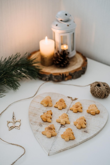 Gezellige kerststemming ambachtelijke zelfgemaakte koekjes kerstboomvorm in houten dienblad op tafel met spar