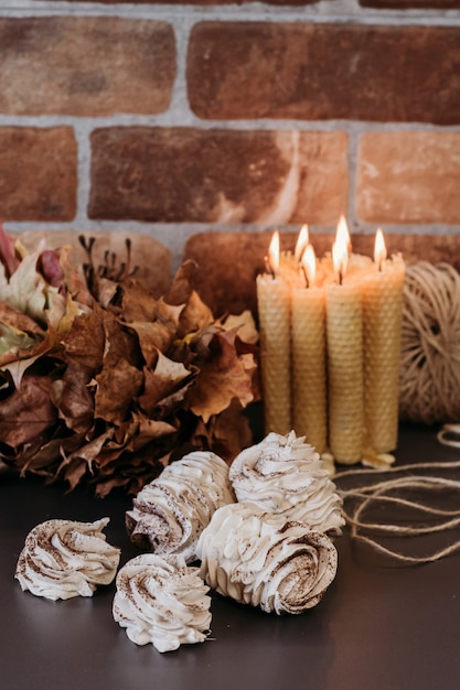 Foto gezellige marshmallows met stilleven, honingkaarsen, koffie. herfst briefkaart.