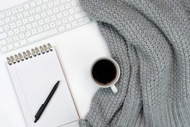 Gezellige werkplek met warme sweater koffie, notitieblok