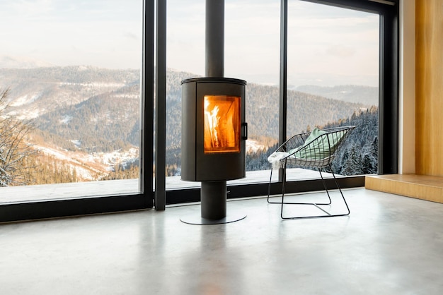 Gezellige woonkamer met open haard en panoramisch raam met geweldig uitzicht op de besneeuwde bergen