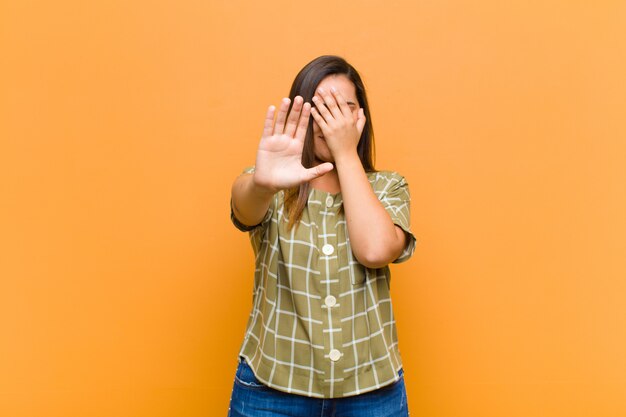 gezicht met hand bedekken en andere hand vooraan zetten om te stoppen, foto's of afbeeldingen weigeren