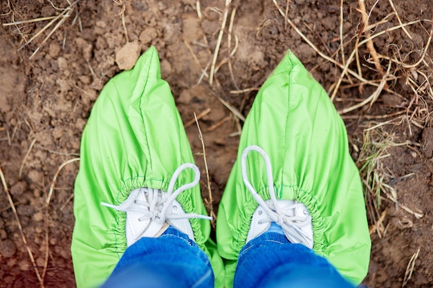 Gezicht op benen in herbruikbare overschoenen. First-person view van de benen. Milieu schoenovertrekken. Eco-producten. Behoud van natuur en milieu