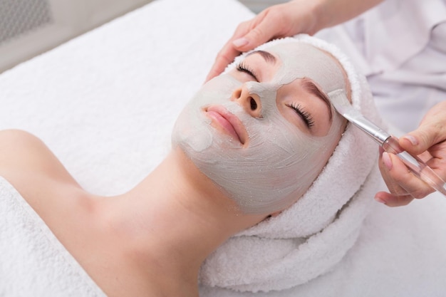 Gezicht peeling masker, spa schoonheidsbehandeling, huidverzorging. vrouw, krijgen, gezichtsverzorging, door, schoonheidsspecialiste, op, spa salon, zijaanzicht, close-up