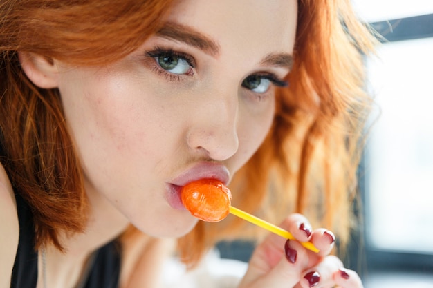 Foto gezicht van mooie jonge vrouw met lolly, close-up