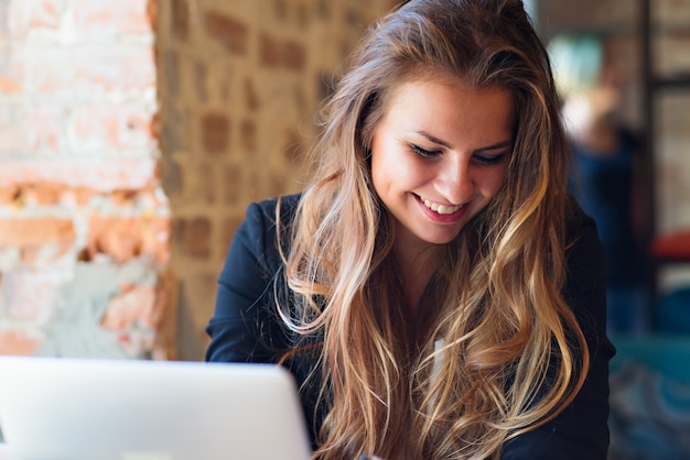 Gezicht van mooie vrouw die aan laptop werkt