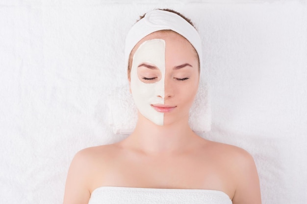 Gezichtsmasker bij spa salon, schoonheidsbehandeling. Vrouw die gezichtskleimasker toepast, ontspan, huidverzorging, bovenaanzicht, overhead