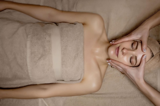 Gezichtsmassage close-up van een jonge vrouw die een spa-massagebehandeling krijgt bij een schoonheidssalon spa huid- en lichaamsverzorging gezichtsschoonheidsbehandeling cosmetologie