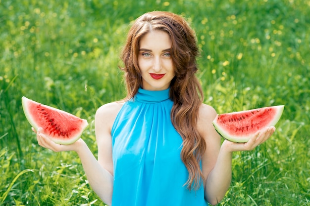 Gezichtsportret van jonge vrouw met twee plakken van watermeloen