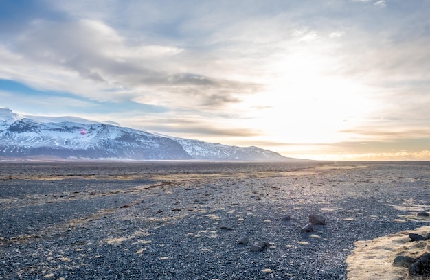 Gezichtspunt naar de Hvannadalshnukur-piek met brede vlakte van zwart vulkanisch zand gemarmerd in IJsland