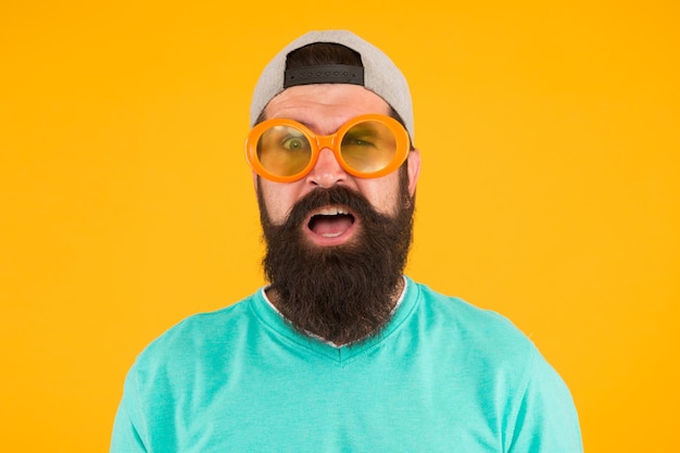 Foto gezichtsvermogen check-ups goed zicht plezier en entertainment grappig accessoire man brillen model grappige zonnebril bebaarde man in zonnebril oranje achtergrond hipster dragen feestzonnebril gezondheid van de ogen