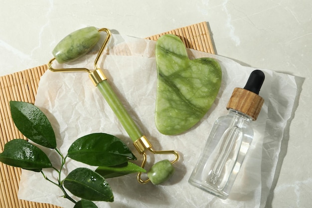 Gezichtsverzorgingsconcept met gua sha gezichtsroller en cosmetica