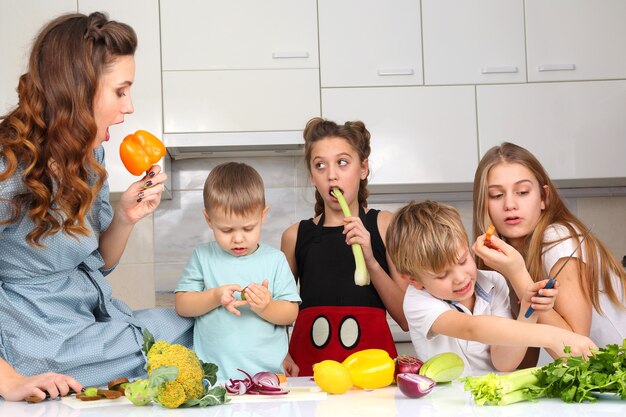 Gezin met kinderen gesneden groenten om te koken