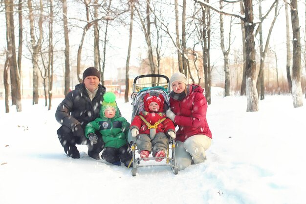 Gezin met kinderen in het park in de sneeuwstorm van de winter