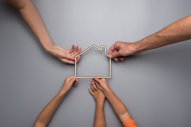 Gezin met kinderen met het kader van een huis op een grijze achtergrond