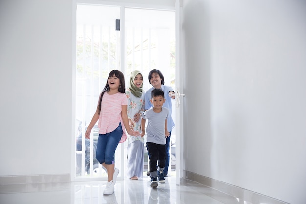 Gezin met twee kinderen die hun nieuwe huis binnengaan