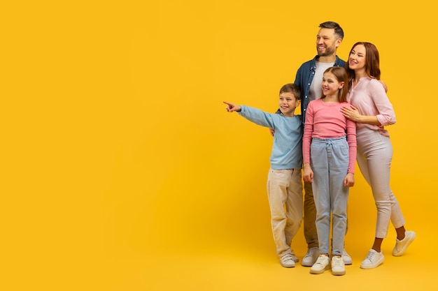 Gezin met twee kinderen die wijzen en glimlachen