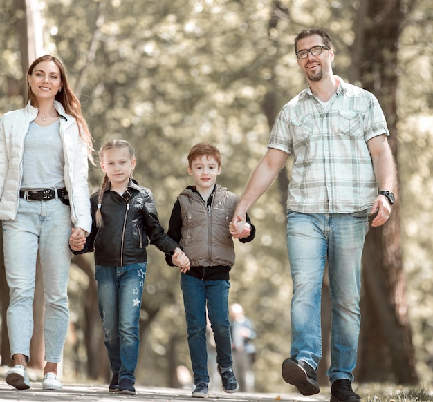 Gezin met twee kinderen op een wandeling in het park