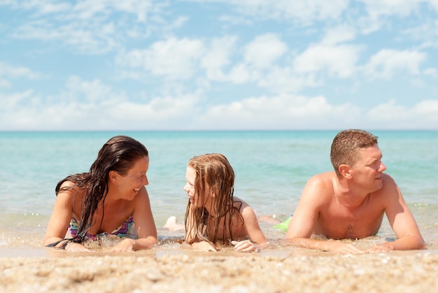 Gezin van drie ontspannen op het strand