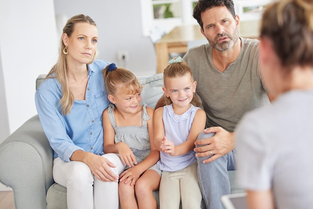 Gezinsbegeleiding van thuisouders maken zich zorgen en luisteren naar de therapeut om hulp voor kinderen te krijgen. Praten met een hulpverlener over een probleem kan kinderen geestelijke gezondheid helpen schoolresultaten en sociaal gedrag