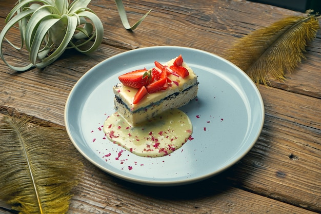 Gezond dessert - kwark braadpan met maanzaad en aardbeien in een plaat op een houten tafel