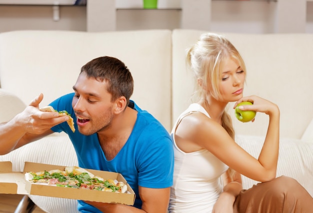 gezond en ongezond voedingsconcept - helder beeld van paar dat ander voedsel eet