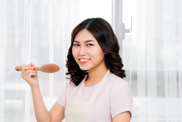 Gezond eten. Aziatische vrouw koken in de keuken met houten lepel