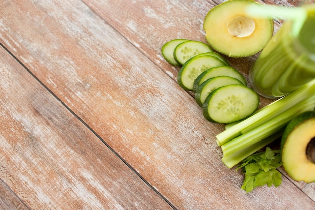 gezond eten, biologisch voedsel, reclame en dieetconcept - close-up van vers groen sapglas en groenten op lege tafel