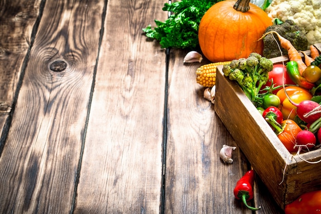 Gezond eten. Biologische groenten in een oude doos. Op houten achtergrond.