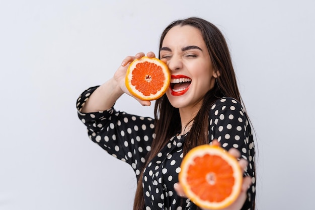 Gezond eten, dieet. Mooi gezond meisje met schijfjes sinaasappelen. Schoonheid jonge mode vrouw speelt met fruit. Vegetarisch.