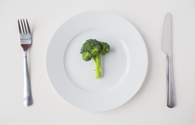 gezond eten, dieet, vegetarisch eten en culinair concept - close-up van broccoli op plaat