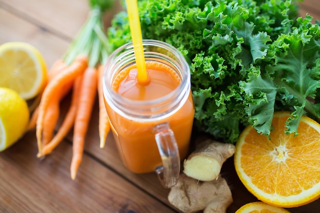 gezond eten, eten, diëten en vegetarisch concept - glazen kan met wortelsap, fruit en groenten op houten tafel