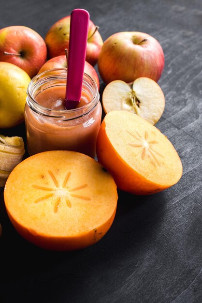 Foto gezond eten. fruityoghurt of puree in glas met verschillende vruchten op zwarte achtergrond. bovenaanzicht. ruimte kopiëren