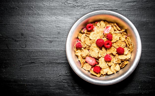 Gezond eten. Muesli met frambozen op zwarte houten tafel.